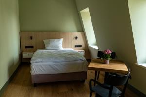 a bedroom with a bed and a table with a chair at Herrenhaus Taucha in Taucha