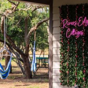 un cartello su un edificio con fiori e un albero di Paintbrush Waterfront Cottage a Morris Ranch