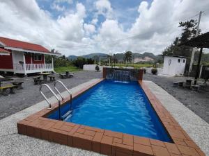 Alor TampangにあるAziqa Homestay Chalet With Poolのテーブルとベンチのある庭のスイミングプール +15枚の写真