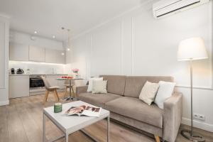 a living room with a couch and a table at Golden Apartments - Mennica Residence Luxury Stay in Warsaw