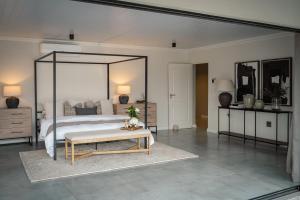 a bedroom with a large canopy bed and a table at Kénōsis Guestfarm- Two Bedroom Apartment in Springbok
