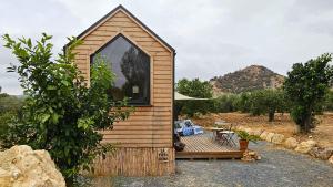 a small wooden cabin with a deck and a table at La Vista Huma by Tiny Away in Alora +4 photos