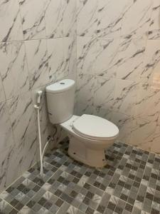 ein weißes WC im Bad mit Marmorwänden in der Unterkunft House of Toti in Yogyakarta