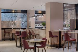 a restaurant with tables and chairs and a bar at NH Bologna De La Gare in Bologna