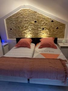 ein Bett mit zwei Kissen darauf in einem Zimmer in der Unterkunft à 10 minutes Futuroscope in Vendeuvre-du-Poitou + 2 Fotos