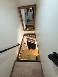 eine kleine Küche mit Spüle und Spiegel in der Unterkunft à 10 minutes Futuroscope in Vendeuvre-du-Poitou