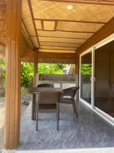 a patio with a table and chairs under a roof at peaceful turtle camp in Esperanza