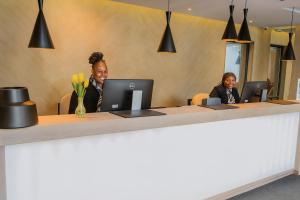two women sitting at a desk with their computers at The Max Hotel Sandton in Johannesburg