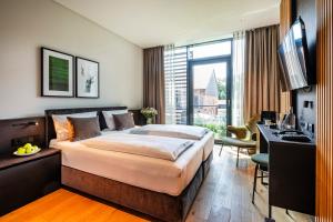 une chambre d'hôtel avec un lit, un bureau et une télévision dans l'établissement Hotel Breitenburg, à Breitenburg