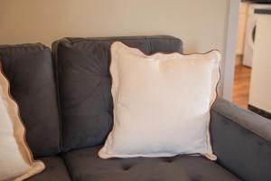 een wit kussen op een leren bank bij 2 BDR Apt At Caledonia Luxe Stays Short Lets & Serviced Accommodation Airdrie in Airdrie