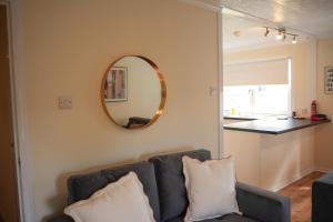 een woonkamer met een bank en een spiegel bij 2 BDR Apt At Caledonia Luxe Stays Short Lets & Serviced Accommodation Airdrie in Airdrie