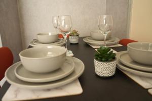a black table with white plates and wine glasses at Bonkle House in Wishaw +30 photos