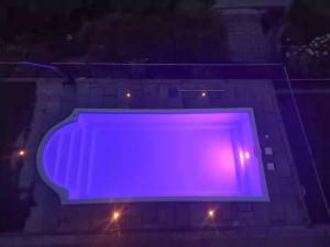 a large purple sign on a building at night at Perla del Lago in Carmine +14 photos