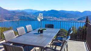 a blue table and chairs on a balcony with mountains at Perla del Lago in Carmine