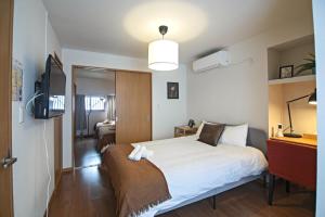 een slaapkamer met een groot bed en een televisie bij Osaka - House - Vacation STAY 16353 in Osaka