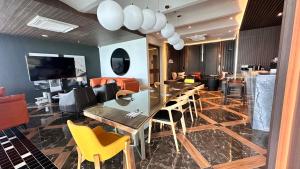 a dining room with a table and yellow chairs at Luxury, Cosy Seaview 1 bed Suite near SICC, Cuckoo in Kota Kinabalu