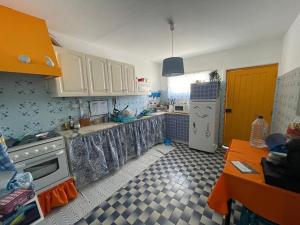 eine Küche mit weißen Schränken und einem weißen Kühlschrank in der Unterkunft Traditional Peniche House in Peniche