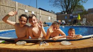 drie jongens op een surfplank in een zwembad bij Sabershausen Landhof Sonne in Sabershausen