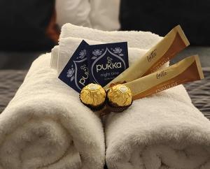 a pile of white towels with two bottles of toiletries at Mackenzie Motels in Fairlie