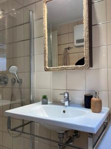 a bathroom with a sink and a mirror at Daphne Glyfada Corfu in Glyfada