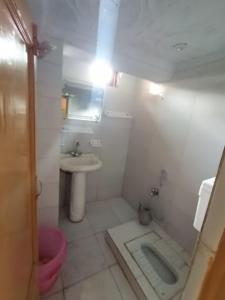 a white bathroom with a sink and a toilet at Jamal Lodge & Family Flats in Dargai