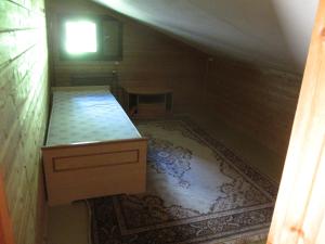 an attic room with a bed and a rug at Gasthause in Rautjärvi