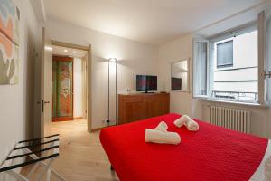 ein Schlafzimmer mit einem roten Bett mit zwei Handtüchern darauf in der Unterkunft Borgo 19 - Centro Como in Como