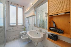 ein Badezimmer mit Waschbecken, Toilette und Spiegel in der Unterkunft Borgo 19 - Centro Como in Como + 19 Fotos