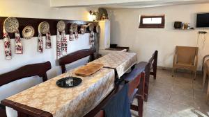 comedor con mesa y platos en la pared en Pensiunea Casa Rica Calimanesti Caciulata, en Călimăneşti