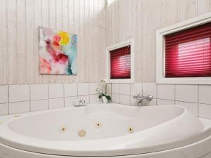 a white bath tub in a bathroom with two windows at 4 star holiday home in Svendborg in Svendborg +27 photos