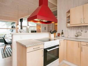 a kitchen with a red hood over a stove at 4 star holiday home in Svendborg in Svendborg