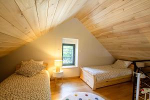 a attic room with two beds and a window at La maison d'elena in Thiviers