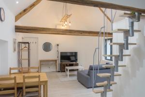 een woonkamer en eetkamer met een wenteltrap bij La Maison Authentique - Maison de charme à seulement 5 mn de Saint Denis de l'Hôtel, 10 mn de Châteauneuf sur Loire et 20 mn d'Orléans in Jargeau