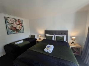 a hotel room with two beds with towels on them at Mackenzie Motels in Fairlie