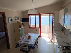 a kitchen with a table and a view of the ocean at Stella Marina in Bova Marina
