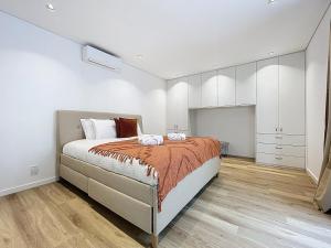 a bedroom with a large bed and white cabinets at Breeze House 2 by Atlantic Holiday in Garajau