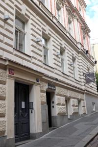 a white building with a black door on a street at Sophie's Hostel in Prague