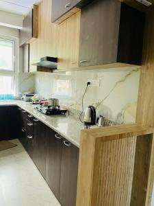 a kitchen with wooden cabinets and a counter top at Karma Service Apartment in Jaigaon