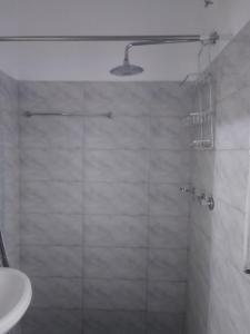a shower with a glass door and a sink at Roadstar Homes agency in Watamu