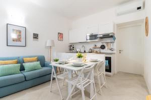 a living room with a table and a blue couch at Cozy 1 BDR - Downtown Milan Navigli, Duomo in Milan