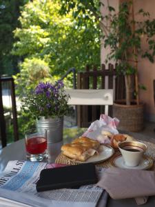 Ca' Rosa Bed & Breakfast في Malnate: طاولة مع طبق من المعجنات وكتاب