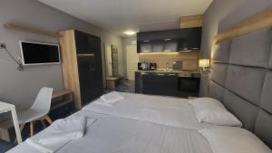 a bedroom with a white bed and a kitchen at Marina Beach Apartments Pomorie in Pomorie
