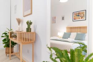 a bedroom with a bed and a table with a plant at Cozy 1 BDR - Downtown Milan Navigli, Duomo in Milan +10 photos