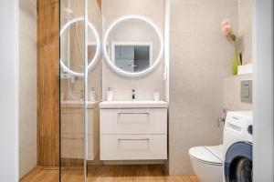 een badkamer met een witte wastafel en een spiegel bij MiCasaEsSuCasa with free parking! in Gdańsk +11 foto's