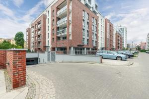 een parkeerplaats met auto's geparkeerd voor een gebouw bij MiCasaEsSuCasa with free parking! in Gdańsk
