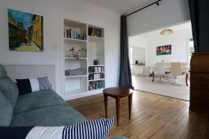 a living room with a green couch and a table at Maison cosy avec jardin proche plage et forêt in Grand-Village-Plage