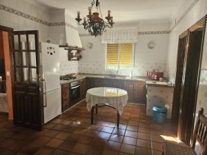a kitchen with a table and a white refrigerator at Casa Rural Los Chorros de Joyarancón in La Presa