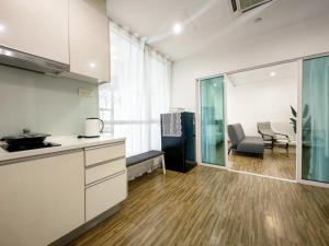 a kitchen with white cabinets and a table and chairs at Setapak Central Mall KL - Zetapark Garden Suites in Kuala Lumpur