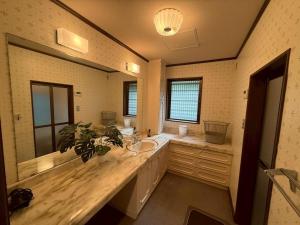 een badkamer met een wastafel en een grote spiegel bij Sea SIDE TERRACE in Toba +21 foto's