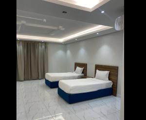 two beds sitting in a room with at شقق سدو المخدومة in Riyadh
